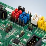 Close-up view of a motherboard with diverse jumper cap colors indicating their meanings.