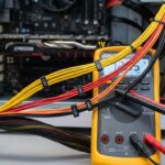 Multimeter displaying PSU voltage readings with colored wires