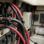 Close-up view of 12V wiring with color codes and warning signs