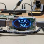 USB multimeter showing voltage and current readings